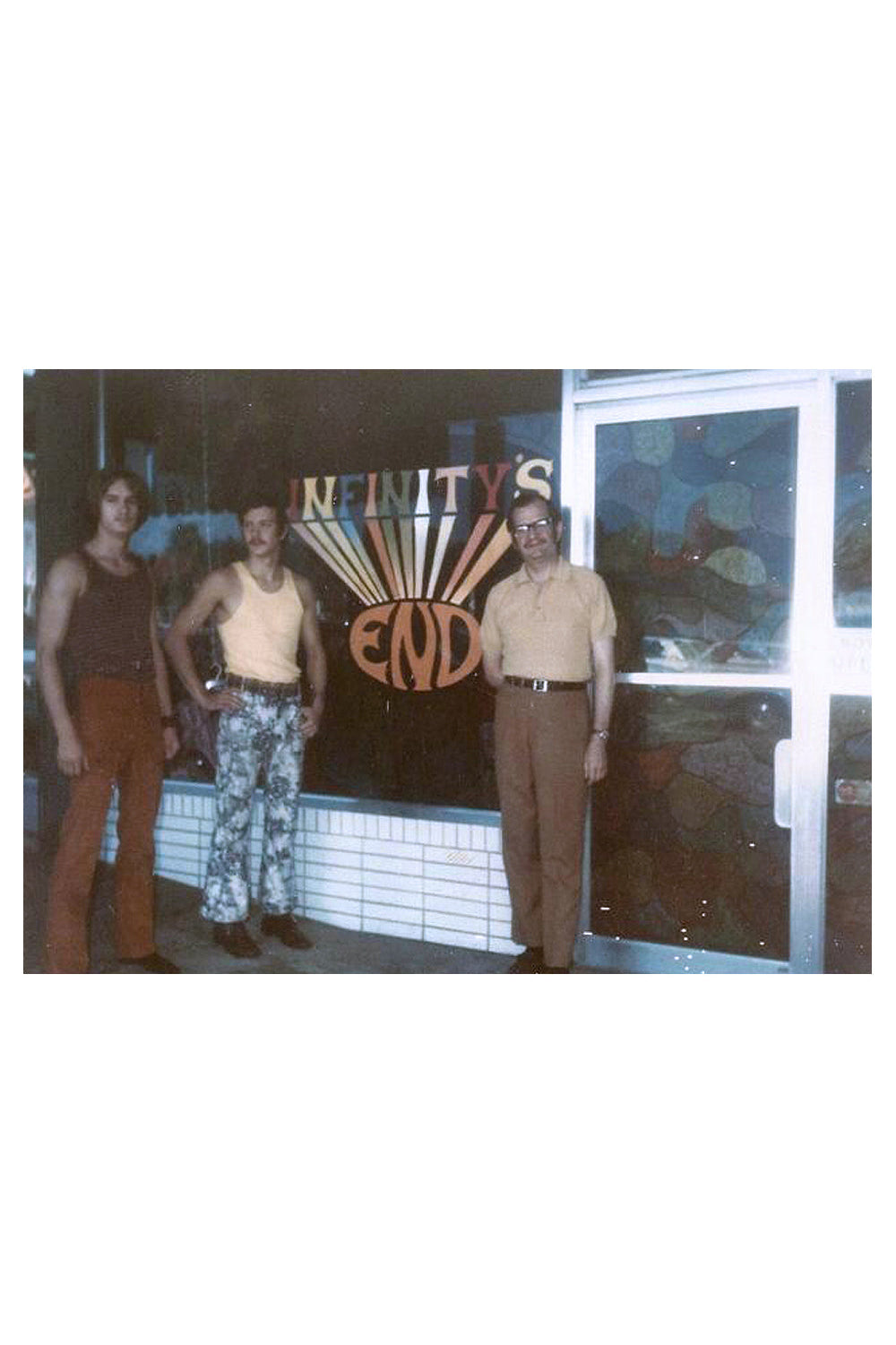 Three men standing in front of a store with a sign that reads 'Infinity's End'.
